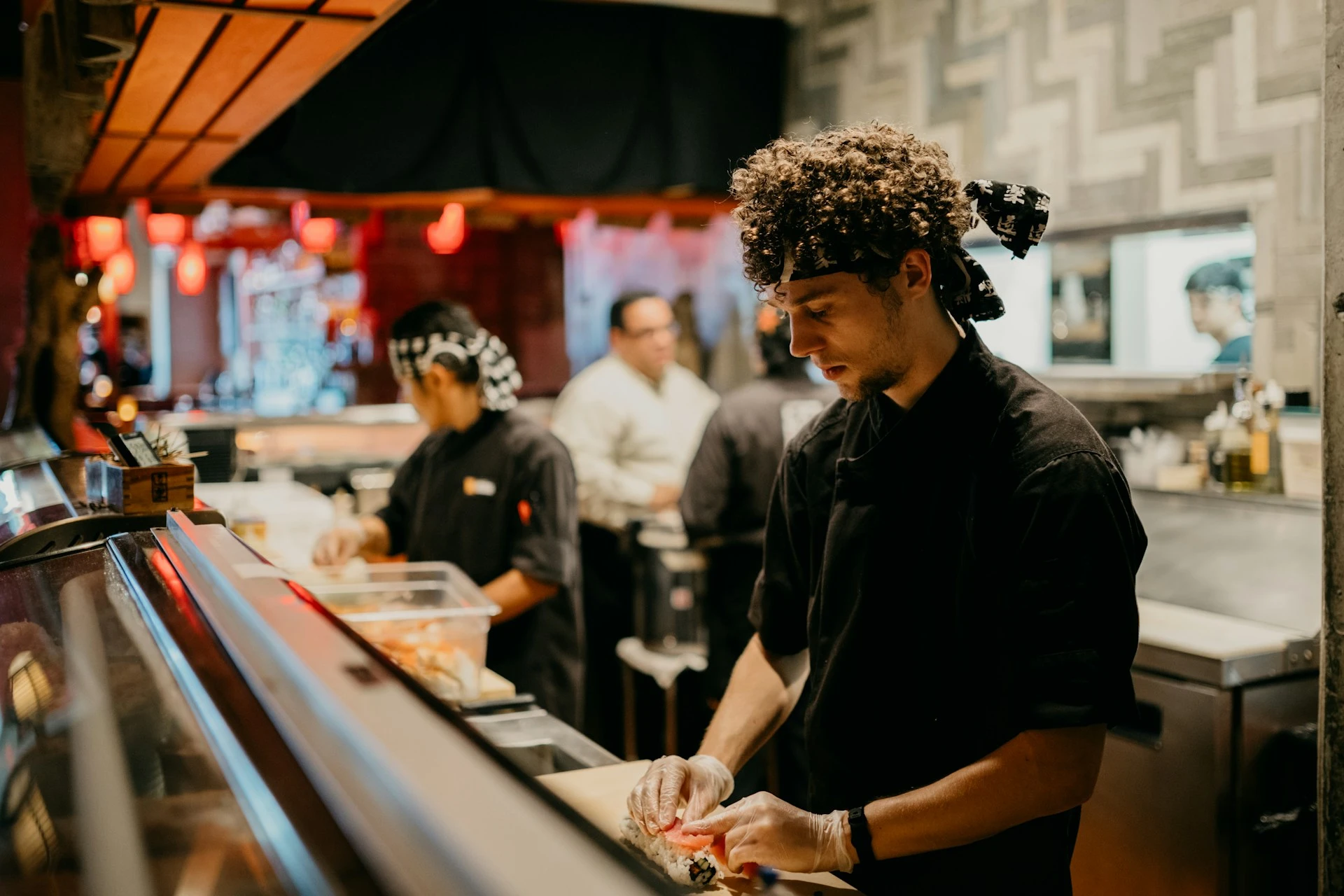 Sushi chefs rolling sushi.